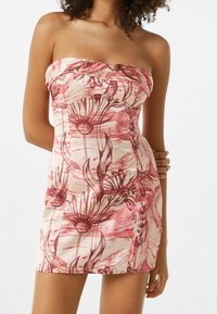 Strapless pink dress with floral pattern in burgundy tones. Smooth fabric, fitted design, and side buttons. Short length.