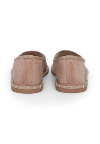 Scarpe slip-on rosa chiaro con una texture morbida, bordi elasticizzati e un bordo intrecciato in contrasto lungo la suola. Suola piatta in gomma.