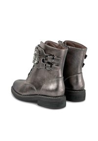 Botas tobilleras de color gris metálico con dobles hebillas laterales, cordones en la parte delantera, tacón bajo apilado y un broche decorativo de cristal en el lado exterior.