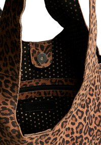 Sac fourre-tout avec imprimé léopard, en texture suédine douce. L'intérieur présente un motif à pois, une poche zippée et une fermeture à pression. Couleurs marron et noir.