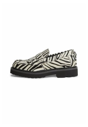 Loafersko med sorte og hvide zebrastriber, tyk sort sål og moc toe-syning, set fra siden på hvid baggrund.