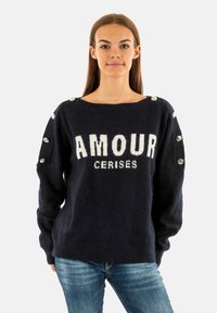 Maglione lavorato a maglia navy con la scritta "AMOUR CERISES" in bianco, caratterizzato da dettagli con bottoni sulle spalle e maniche ampie.