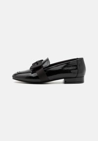 Mocasines de charol negro con detalle de lazo y una cinta de satén. Diseño elegante con un tacón bajo y textura suave.