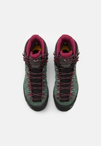 Green and black hiking boots with maroon accents, featuring a textured upper, reinforced toe cap, and lacing system, designed for outdoor use.