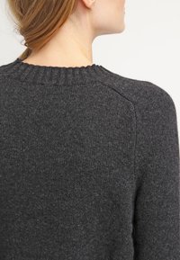 Ciemnoszara wełniana sweter z prążkowanym okrągłym dekoltem, charakteryzujący się teksturowanym splotem i dopasowanym krojem, pokazany z tyłu.