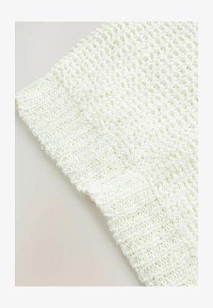 Bílá texturovaná textilie s tkaným vzorem, se kontrastním žebrovaným okrajem na spodní straně. Měkký, lehký vzhled.
