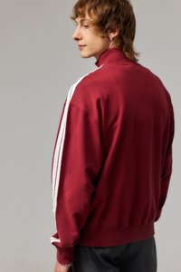 Tumedate särk, millel on kõrge krae, valged külje triibud, soonikkoes varrukad ja alläär, pehme tekstuur, vaade seljast.