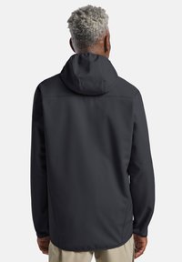 Veste à capuche gris foncé, au tissu lisse et à la coupe ajustée. Elle possède des manches longues et un ourlet arrière légèrement plus long.
