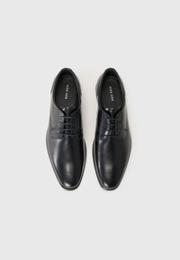 Schwarze Lederdressschuhe mit glatter Textur, abgerundeter Spitze und klassischer Schnürung. Innenraum mit Branding. Die Sohlen sind flach und elegant.