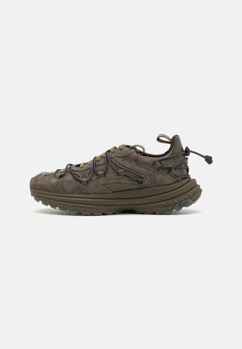 Baskets en suede marron foncé avec une finition texturée, dotées de lacets élastiques, d'une languette et d'une semelle Vibram pour une meilleure adhérence.
