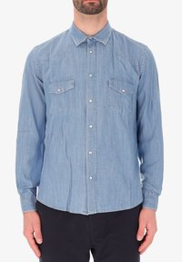 Camicia in chambray azzurro chiaro con colletto a bottoni, due tasche sul petto e maniche lunghe, caratterizzata da una trama liscia e dettagli di cucitura discreti.