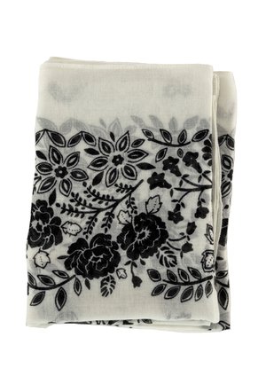 Tela blanca doblada con patrones florales y de hojas negras a lo largo de los bordes.