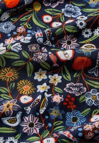 Katoenen stof met een marineblauwe achtergrond en kleurrijke bloemen- en vissenpatronen in rood, roze, geel en blauw, met groene loofaccenten.