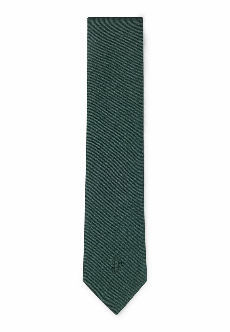 Cravate tissée verte foncée avec une finition texturée et une pointe effilée. Un branding subtil est embossé près de la pointe pour le détail.