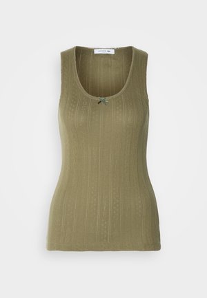 Débardeur sans manches de couleur olive, présentant une texture côtelée avec des motifs subtils et un accent décoratif en forme de nœud vert près de l'encolure.