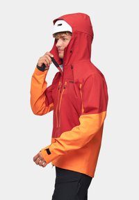 Czerwono-pomarańczowa wodoodporna kurtka z kapturem, z zamykanymi kieszeniami, regulowanymi mankietami i dwutonowym wzorem. Odpowiednia do aktywności na świeżym powietrzu.
