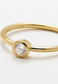 Anello d'oro con una pietra chiara, tonda e sfaccettata, incastonata in una fascia liscia e arrotondata con una finitura lucida. Design semplice ed elegante.