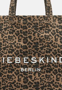 Torebka tote w panterkę, wykonana z trwałego materiału, z brązowo-czarnym wzorem oraz białym napisem "Liebeskind" i "BERLIN."