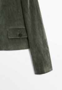 Olive green jacket with a soft, textured fabric. Features a single black button on the sleeve and a side pocket with button closure.