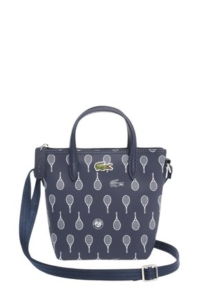 Petit sac à main bleu marine avec motif raquette de tennis blanche, logo crocodile vert, poignées courtes et bandoulière réglable.