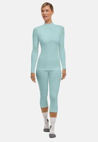 Lichtblauw sportoutfit met een lange mouwen top en cropped leggings. De stof lijkt glad met naadloze constructie, wat het comfort verhoogt.