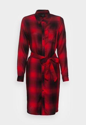 Vestido camisa de cuadros rojos y negros, mangas largas, cierre delantero con botones, un bolsillo en el pecho, cinturón de tela, textura suave.