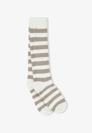 Térdig érő zoknik bézs és fehér csíkos mintával. Puha kötött anyagból készültek, a tetejükön bordázott szegéllyel.