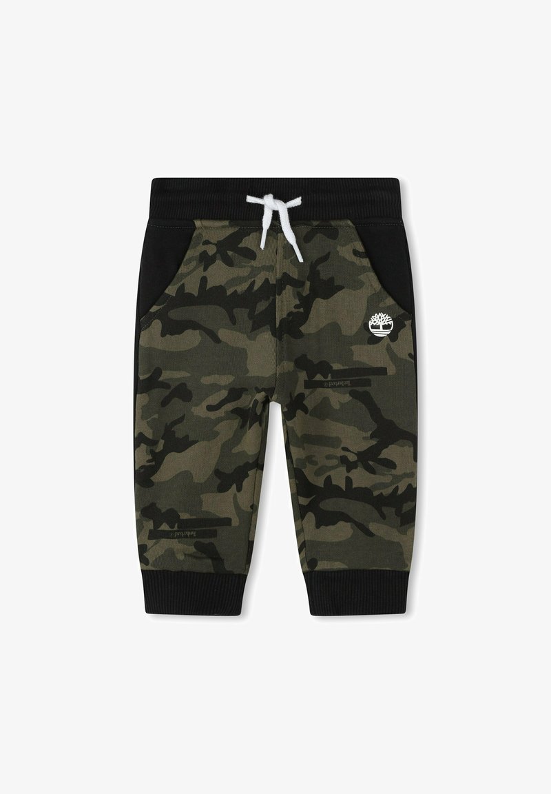 Pantalon de jogging camouflage vert et noir pour enfants avec poignets côtelés noirs, panneaux latéraux noirs, cordon blanc et logo arbre blanc sur la jambe.