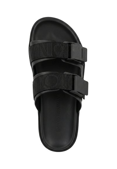 Sandale à glissière noire avec deux brides en tissu réglables et grandes boucles en plastique, semelle intérieure texturée et nom de la marque embossé sur la semelle.