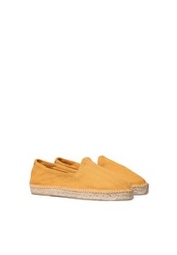 Žute espadrile s teksturiranim gornjim dijelom, slip-on stilom i pletenom jutu potplatom. Okrugli nožni prst i skriveno šivanje oko rubova.