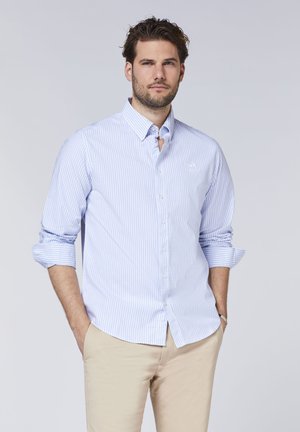 Light blue and white striped long-sleeve shirt with button-down collar, featuring rolled sleeves and subtle logo detail on chest.
