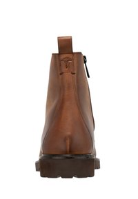 Bota de cuero marrón hasta el tobillo con cremallera, tirador y suela texturizada. Presenta detalles de costura y un logo en el talón.
