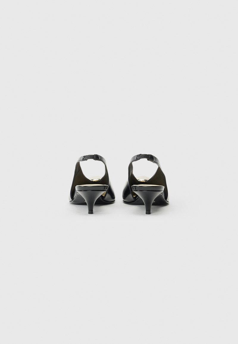 Zapatos de tacón alto de cuero negro con el talón abierto, con un tacón afilado y una textura suave. Detalles dorados en la suela.
