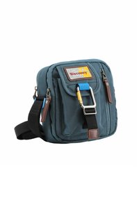 Borsa a spalla in tessuto blu con una tasca frontale a pattina, hardware argentato, dettagli marroni, tracolla regolabile e un patch logo colorato.
