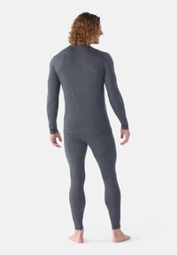 Maglione termico a maniche lunghe grigio e leggings, realizzati in un tessuto liscio e elasticizzato. Design aderente, senza cuciture sui polsi e sulle caviglie.