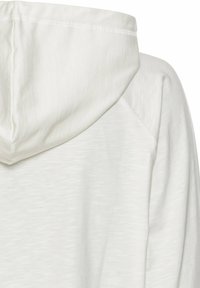 Hættebluser i lys grå med en tekstureret overflade. Hætten har en syet søm, og stoffet er glat og blødt.