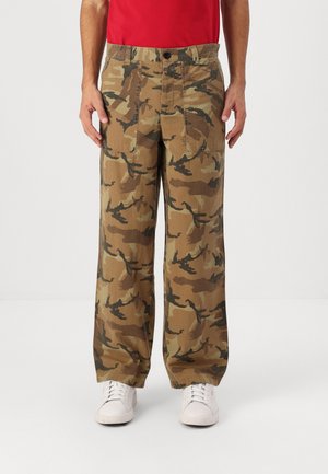 Pantalons cargo camouflage en beige, marron et vert foncé. Caractéristiques de deux poches avant, une coupe droite et une fermeture à bouton à la taille.