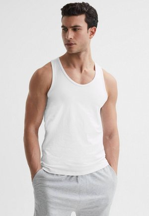 Witte tanktop van katoen, met een ronde halslijn en brede schouderbanden. Draag het met grijze joggingbroek, minimale textuur en ontwerpelementen.