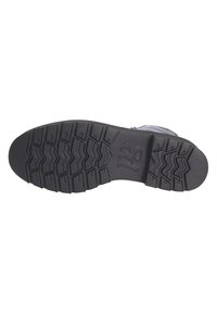 Semelle en caoutchouc noir avec des motifs de bande de roulement profonds, texturée pour une meilleure adhérence. Talon renforcé et bords lisses pour la durabilité et la traction.