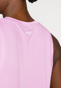 Ροζ αμάνικη μπλούζα με ριμπ λαιμόκοψη και τη λέξη "STRONGER" σε λευκό στο πίσω μέρος, κατασκευασμένη από απαλό, ελαφρύ ύφασμα.