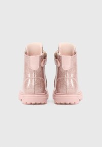 Rosa glittriga ankelstövlar med glänsande yta, släta textilöverdelar, små dragkedjor och strukturerade gummisulor för bra grepp.