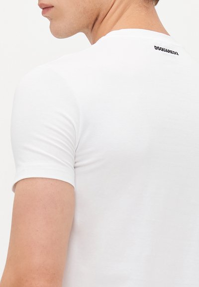 Weißes Kurzarm-T-Shirt aus weicher Baumwolle, mit rundem Ausschnitt und einem schwarzen Logo, das im Nackenbereich auf der Rückseite gedruckt ist.