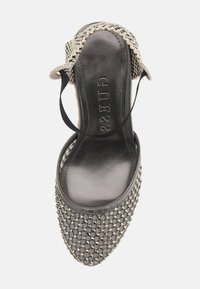 Geweven grijze espadrille met een glanzende zwarte binnenzool, voorzien van elastische banden en textuurperlen langs de bovenrand.
