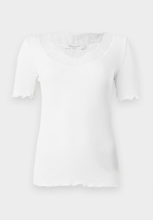 White ribbed short-sleeve top featuring a scalloped neckline and lace detailing at the collar. Scalloped edges on sleeve hems.