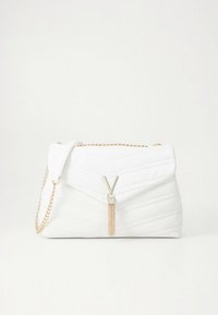 Fehér steppelt kézitáska hajtókás kialakítással, arany láncpánttal és fém bojtos díszítéssel. Csillogó felülettel és texturált csíkokkal rendelkezik.