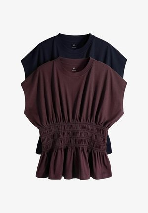 Zwei gefaltete kurzärmelige Oberteile, eines dunkelmarineblau mit einfachem rundem Ausschnitt und eines braun mit geraffter Taille und Schößchen, auf weißem Hintergrund geschichtet.