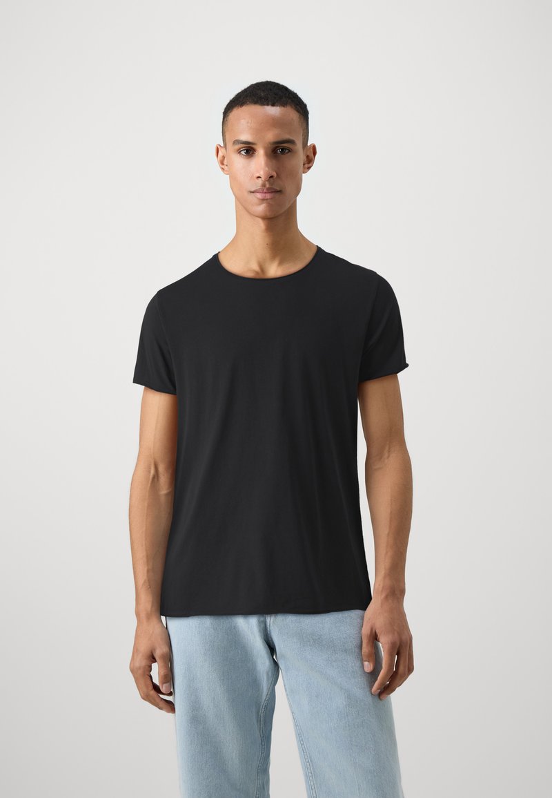 Black short-sleeve t-shirt made of soft fabric, featuring a round neckline and a fitted silhouette, paired with light blue jeans.