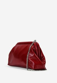 Bolso de mano rojo de cuero con un diseño fruncido, cadena plateada y textura suave y brillante. Forma compacta, adecuada para uso nocturno.