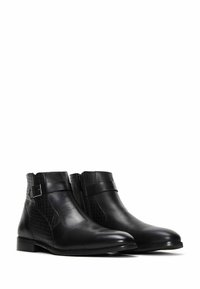 Botas negras de cuero hasta el tobillo con un acabado liso y texturizado, que presentan una cremallera lateral y un detalle de hebilla, con una punta rectangular.