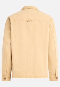 Chaqueta de mezclilla beige clara con mangas largas, cuello extendido y puños abotonados. Cuenta con canesú trasero y detalles de costura.